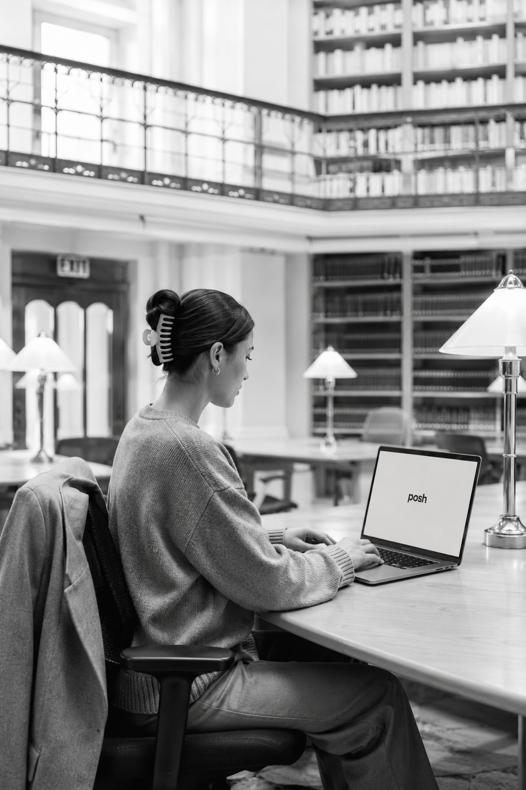 woman working on a laptop in a library, the posh app on screen